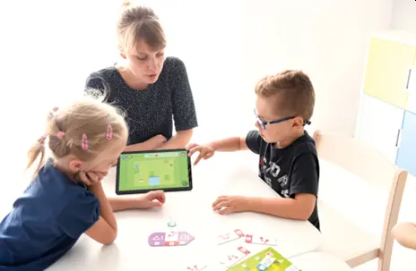 Kinder mit Tablet am Tisch sitzend