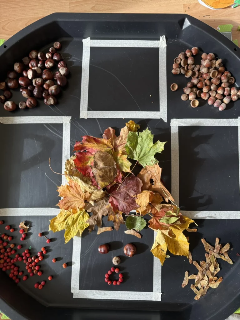 Kinder legen aus Herbstmaterialien Gesichter in verschiedenen Stimmungen