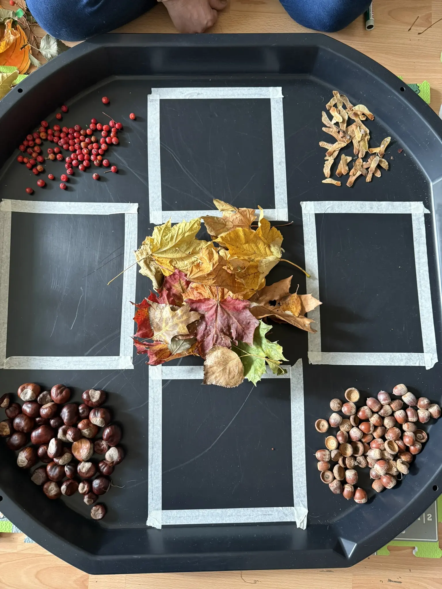 Kinder legen aus Herbstmaterialien Gesichter in verschiedenen Stimmungen