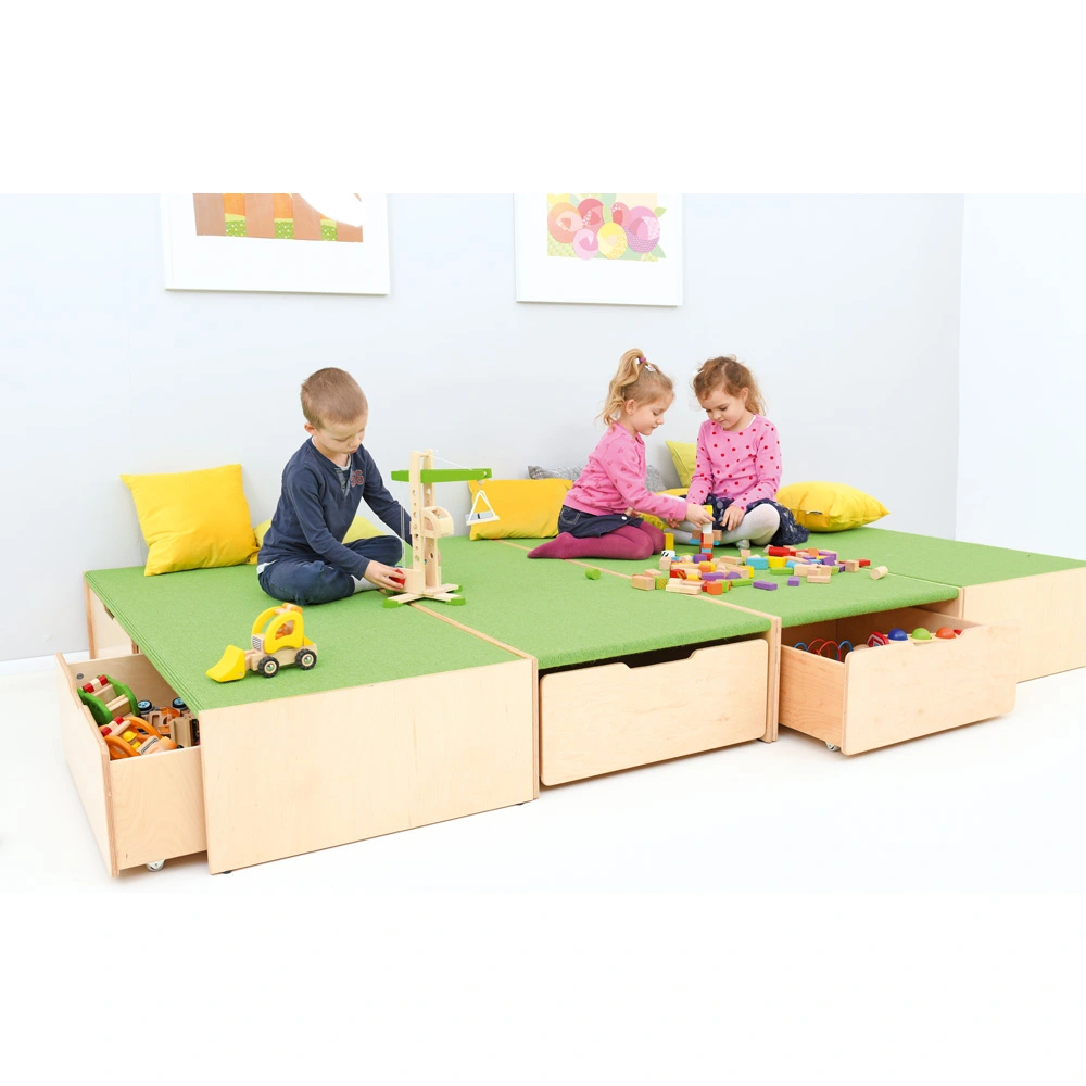 Kinder spielen auf gepolsterten Podesten, Schubladen unter diesen bieten zusätzlichen Stauraum.