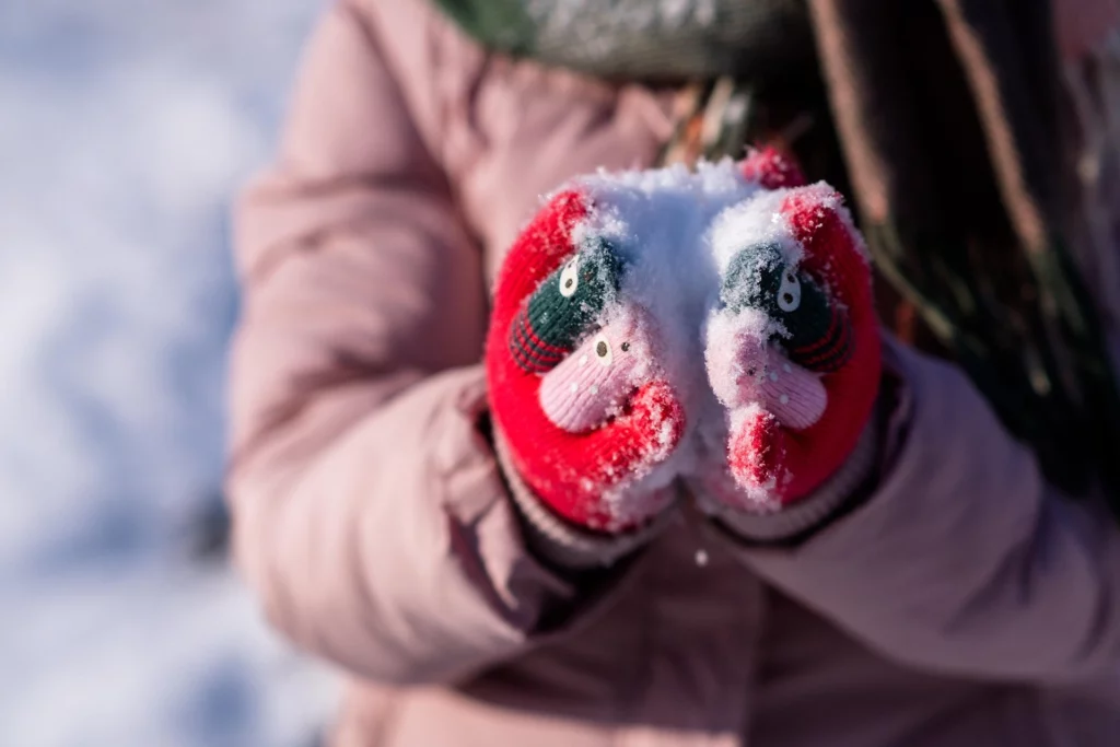 Kindergarten-Kind hält Schnee beim Spielen