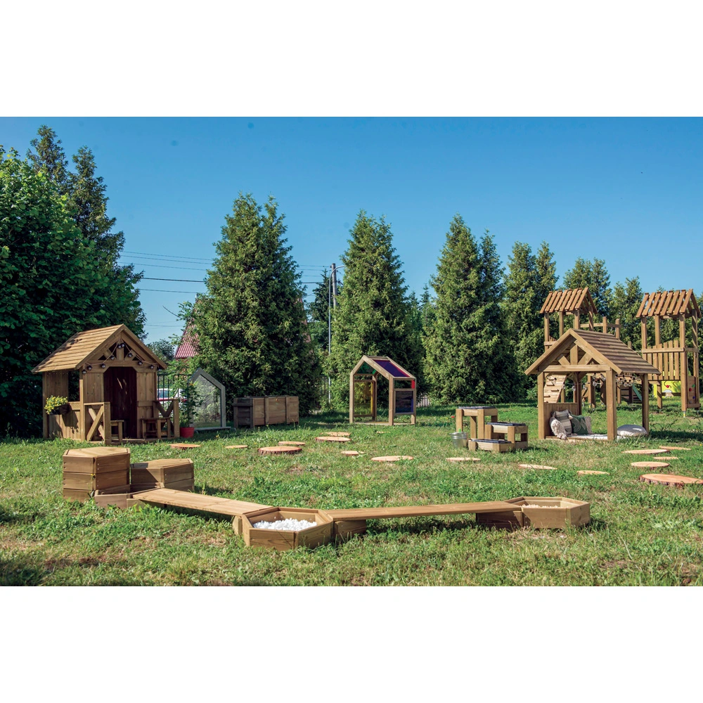 Ein Terra-Spielplatz auf einer Wiese, mit Spielhäuschen, Balancierstegen und Pflanzkästen.