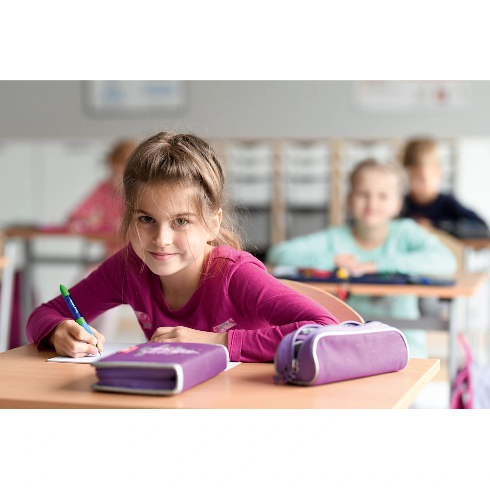 Schülerin sitzt am ersten Schultag an ihrem Arbeitsplatz